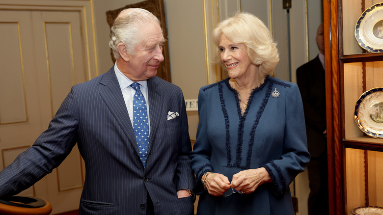 Prince Charles gazes at smiling Queen Camilla 