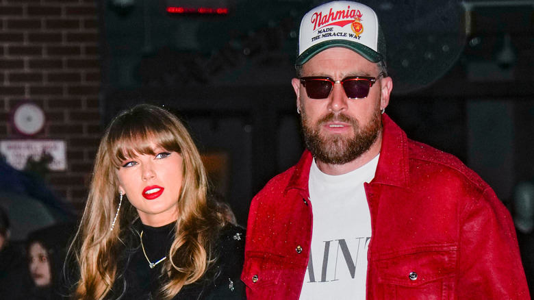 Taylor Swift and Travis Kelce looking deep in thought while walking