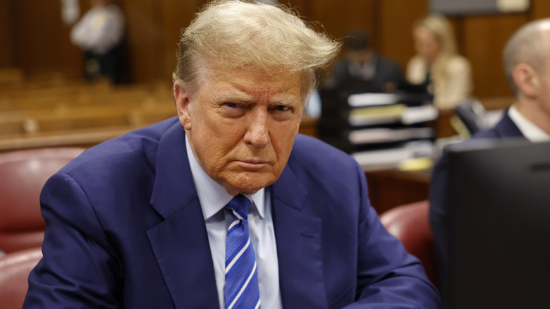 Donald Trump frowning seated in court