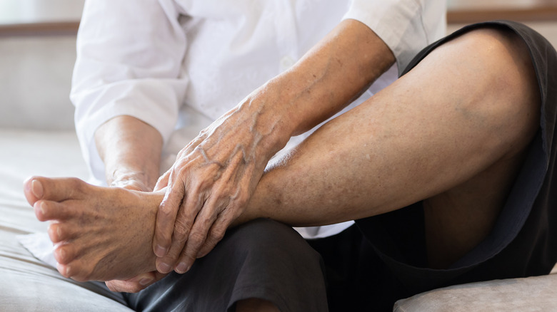 Older woman sitting down and rubbing her feet