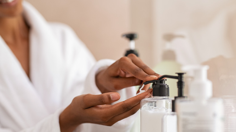 Woman using body lotion