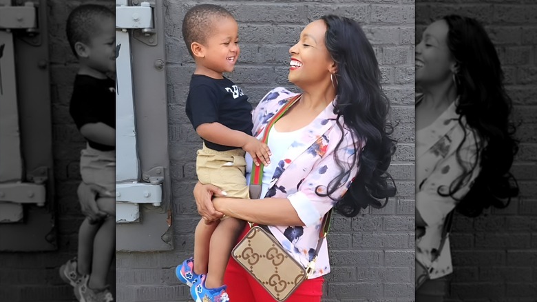 Shea Hicks-Whitfield smiling and holding her son
