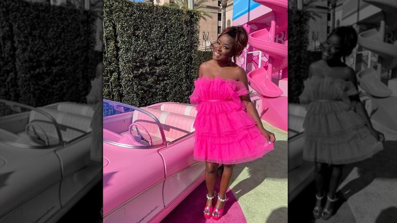 Tiffany Brooks at the Barbie premiere next to a pink car