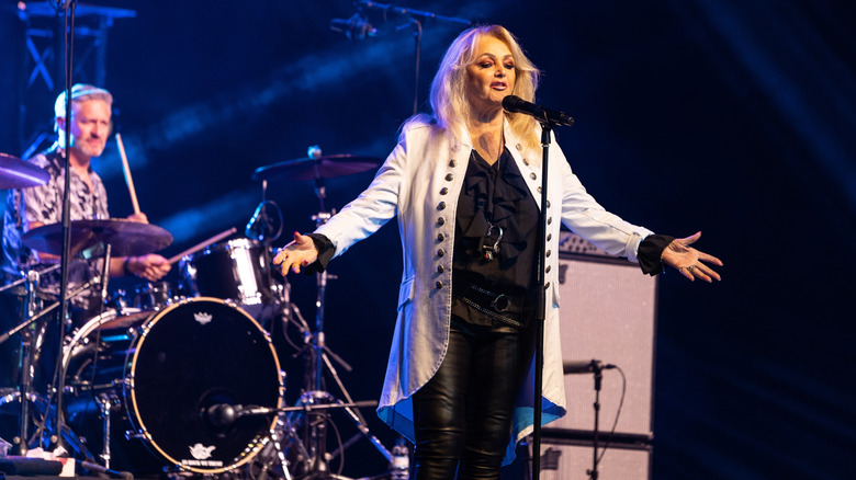 Bonnie Tyler singing onstage with her drummer behind her
