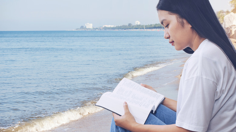 Woman reading book at beach