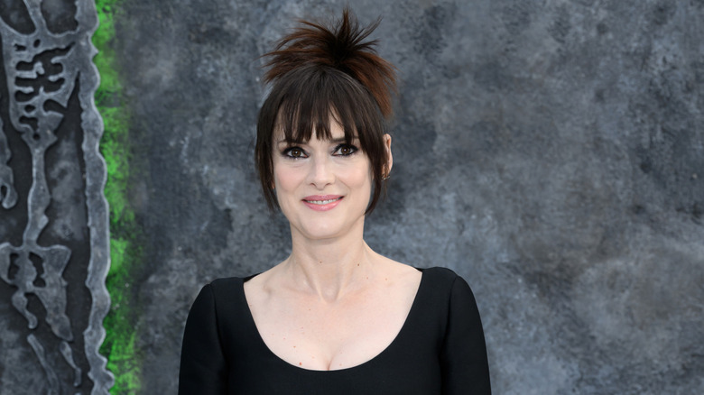 Winona Ryder smiles in a black dress