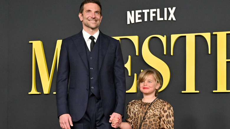 Bradley Cooper holds hands with daughter Lea and smiles