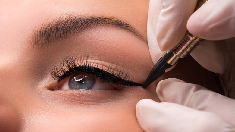 Person lining their eyes with eyeliner