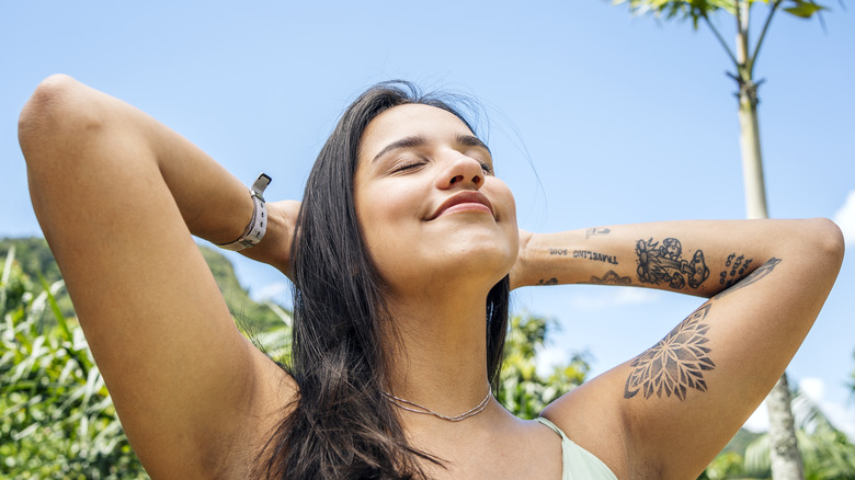 woman with eyes closed smiling into sun