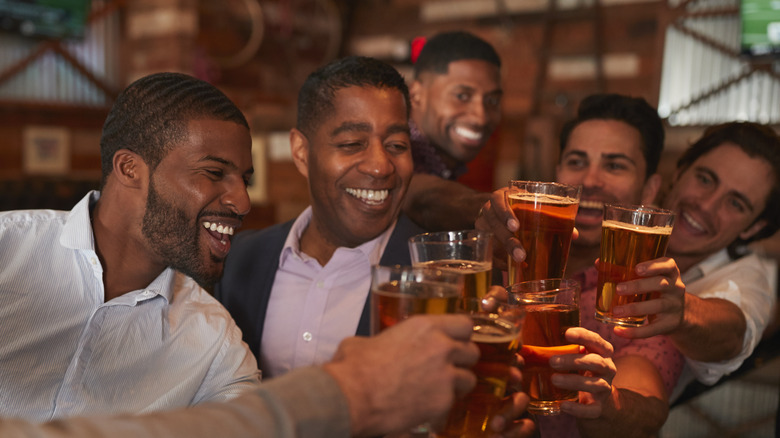 men smiling and toasting with beers