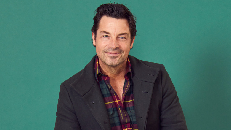 Brennan Elliott posing against green backdrop
