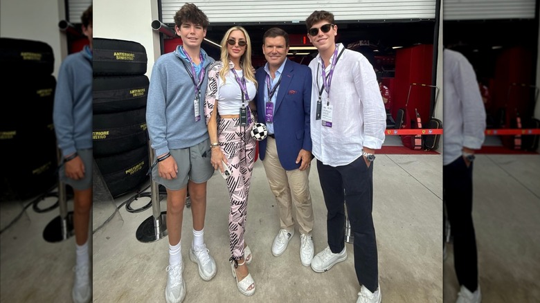 Daniel, Amy, Bret, and Paul Baier standing together outside a race-car pit, with the two sons visibly taller than their parents