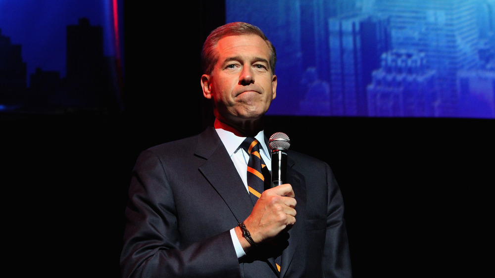 Brian Williams holding a microphone