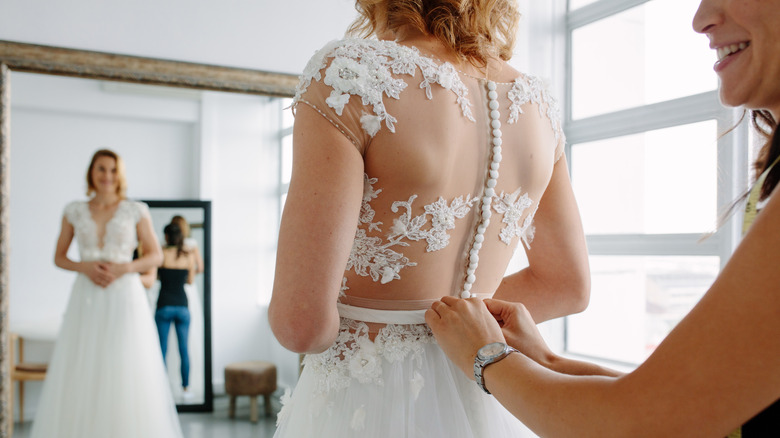 Woman trying on bridal gown