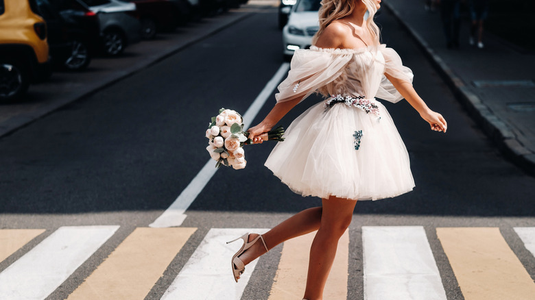 bride in a short dress walking down the street