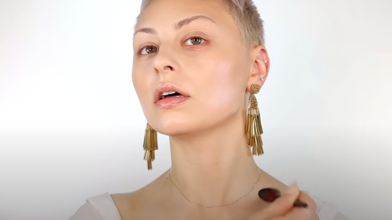 applying bronzer to collar bones