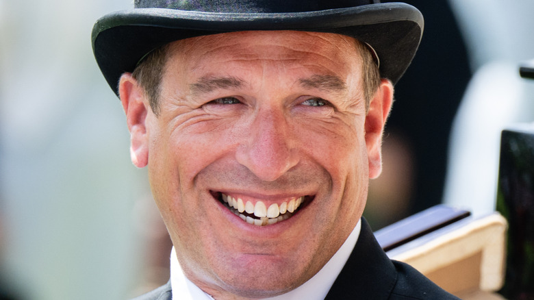 Peter Phillips wears a black top hat and smiles
