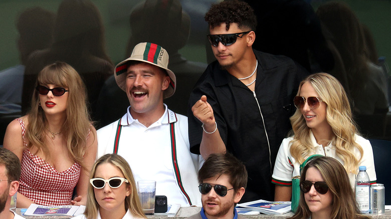 Taylor Swift, Travis Kelcey, and Patrick and Brittany Mahomes watching a game together in the sun