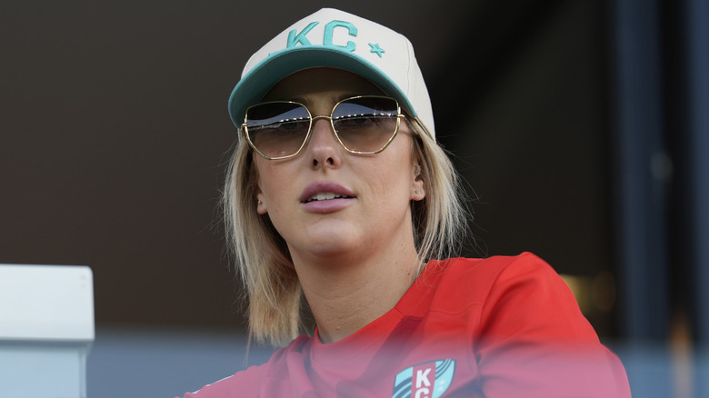 Brittany Mahomes wearing sunglasses and a baseball cap