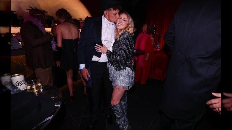 Patrick Mahomes kisses Brittany Mahomes as they pose for a photo during a party (2024)