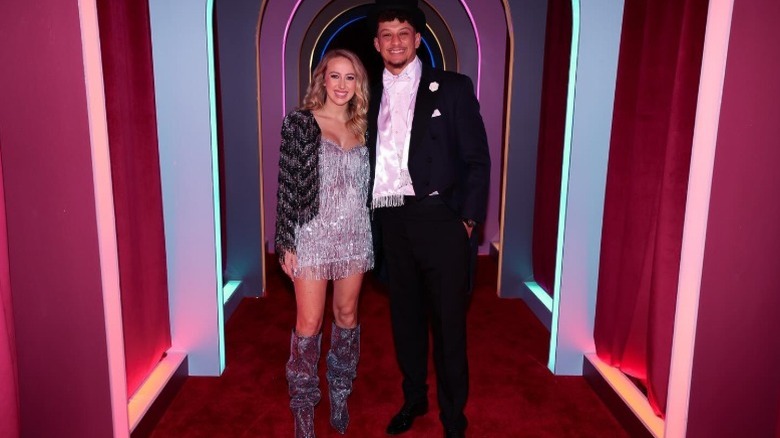 Brittany Mahomes and Patrick Mahomes pose together in a colorful hallway (2024)