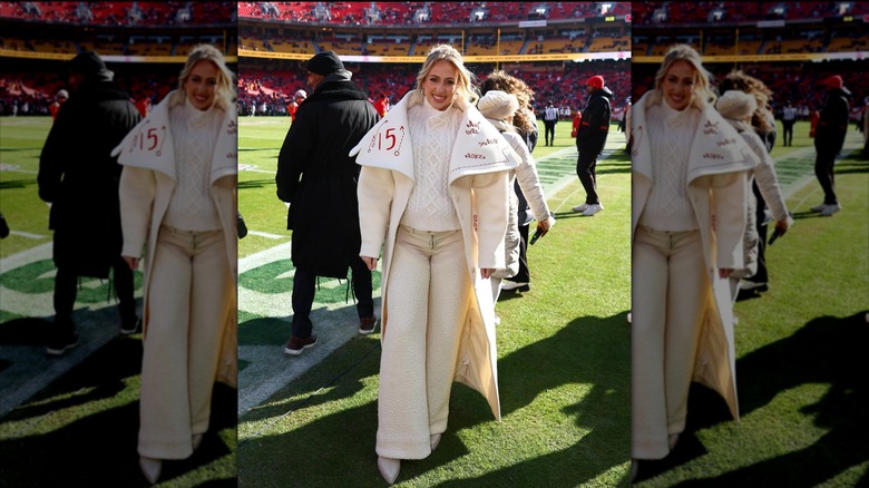 Brittany Mahomes poses on the football field in an all-white outfit