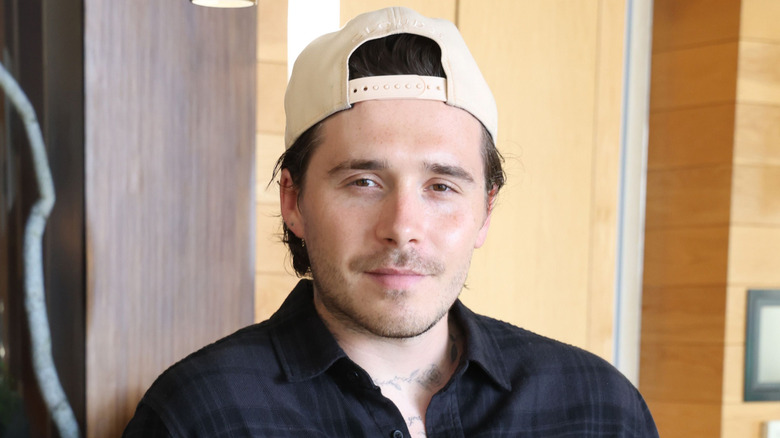 Brooklyn Beckham wearing a backwards hat
