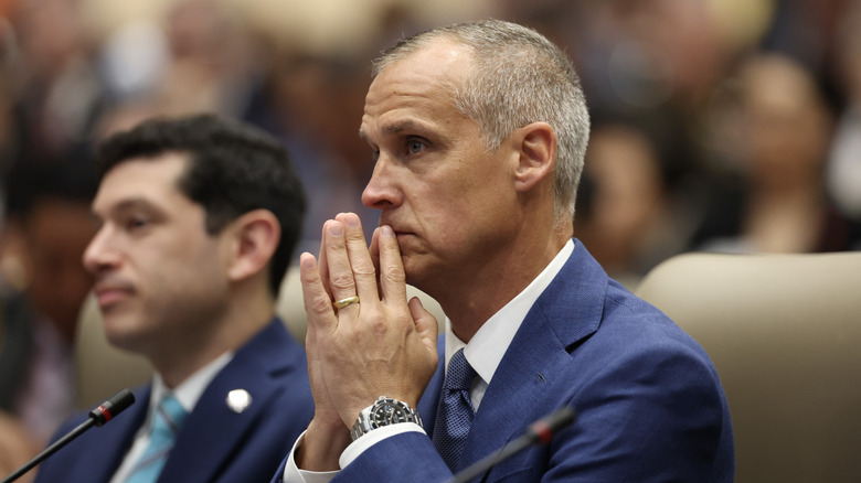 Corey Lewandowski holding his hands together at his face with a visible wedding band