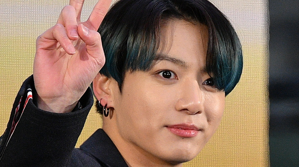 Jungkook giving a peace sign