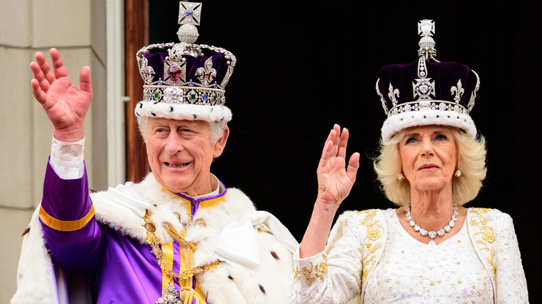 King Charles III and Queen Camilla waving to crowd