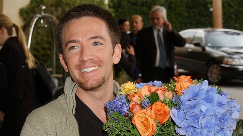 David Faustino holding a bouquet of blue flowers