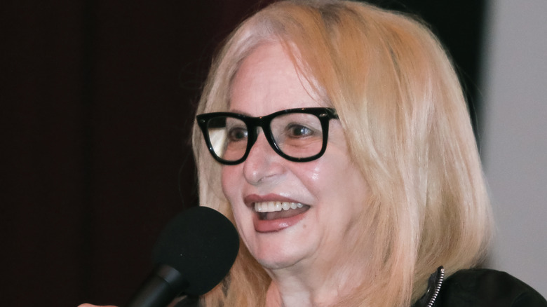 Penelope Spheeris smiling and talking into a microphone.