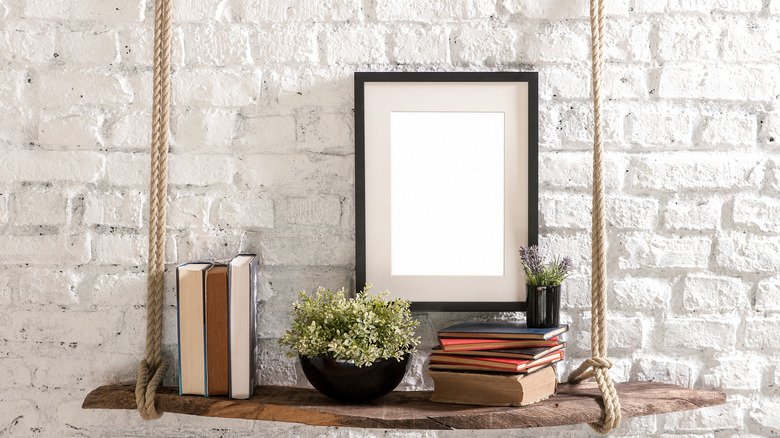 A hanging shelf with books and a plant