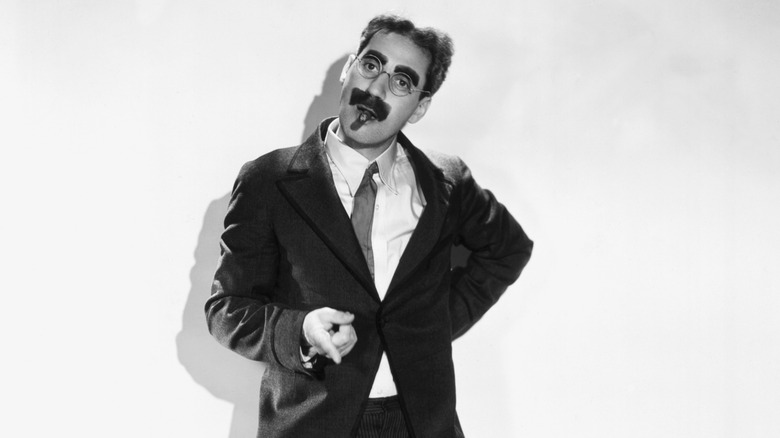 Groucho Marx posing with a cigar in his mouth in 1931.