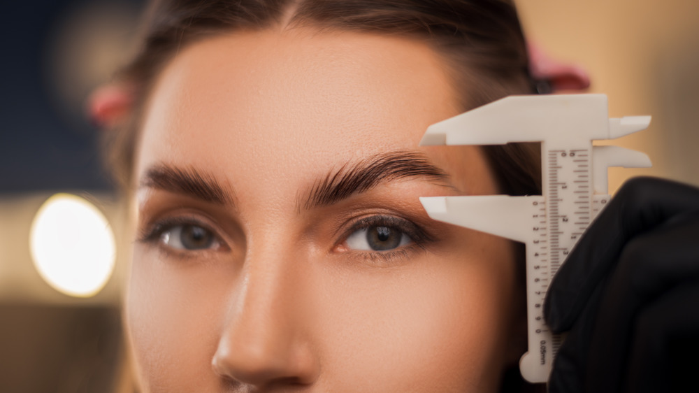 Woman measuring her eyebrows