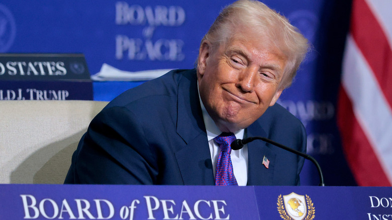 Donald Trump smirking sitting at Board of Peace meeting