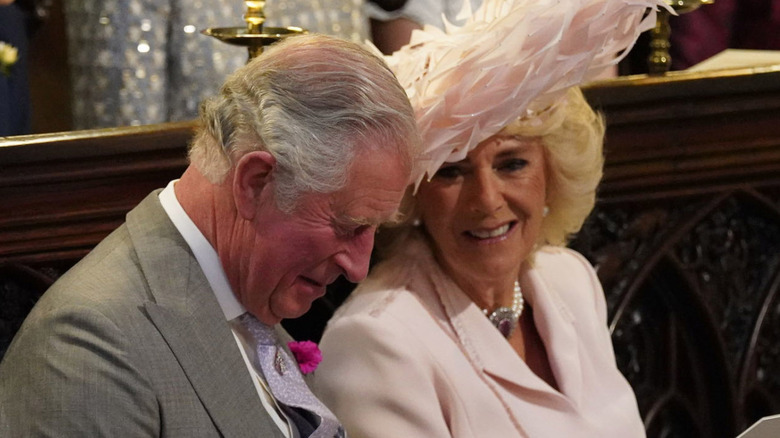King Charles III and Queen Camilla chatting in a church pew