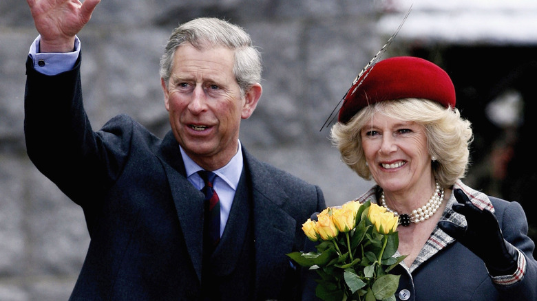 King Charles and Queen Camilla waving at crowds in 2006