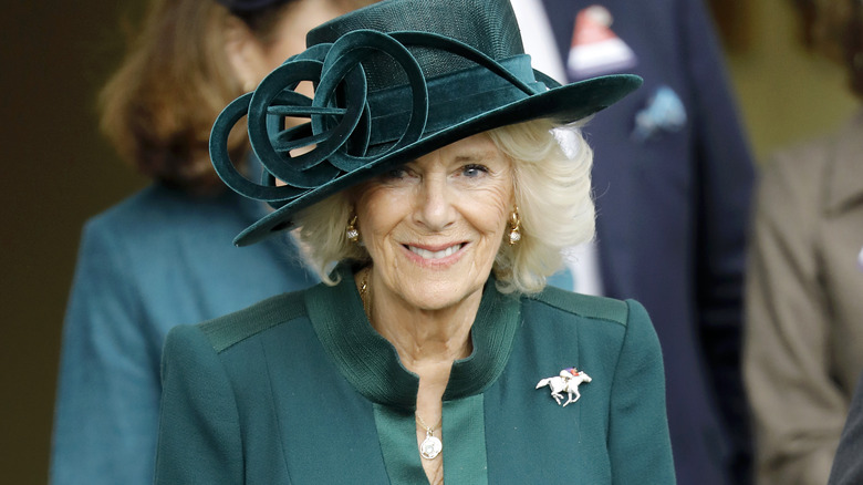 Camilla, Queen Consort smiles in green hat 