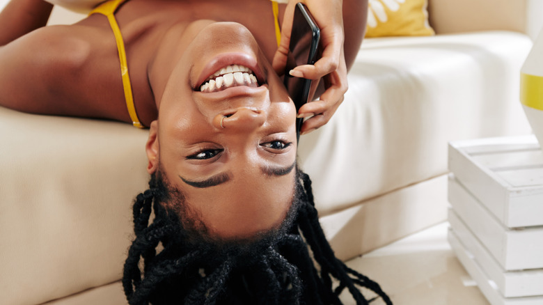 Woman laying with her head upside down