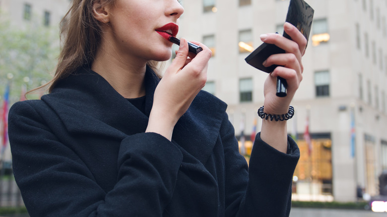 Woman applying lipstick