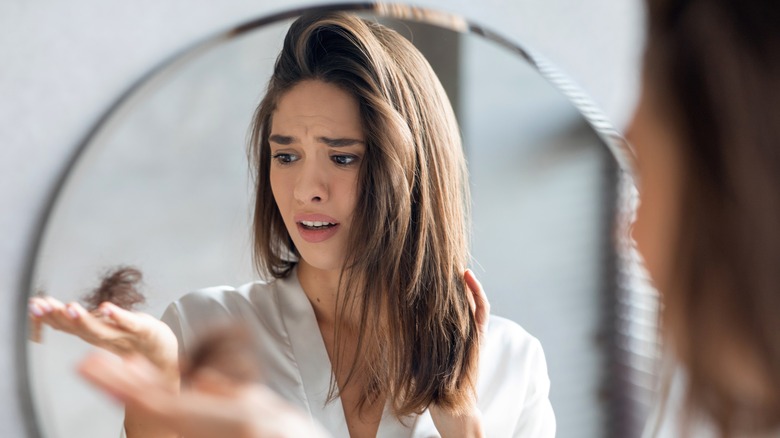 Woman holding clump of hair