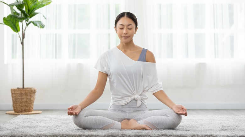 Woman meditating in her home