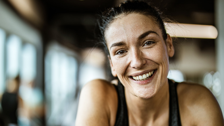 Woman smiling with sweat on face