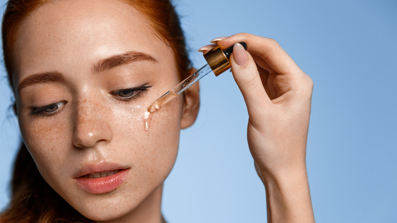 woman applying facial serum