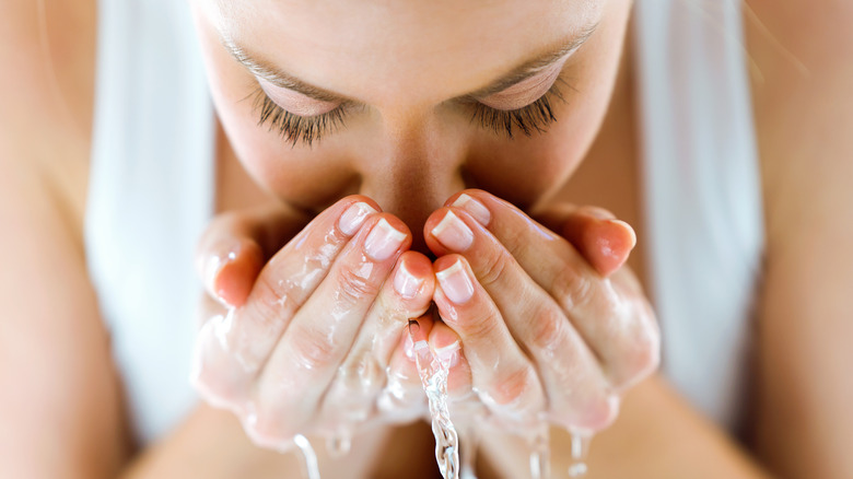 Woman washes her face