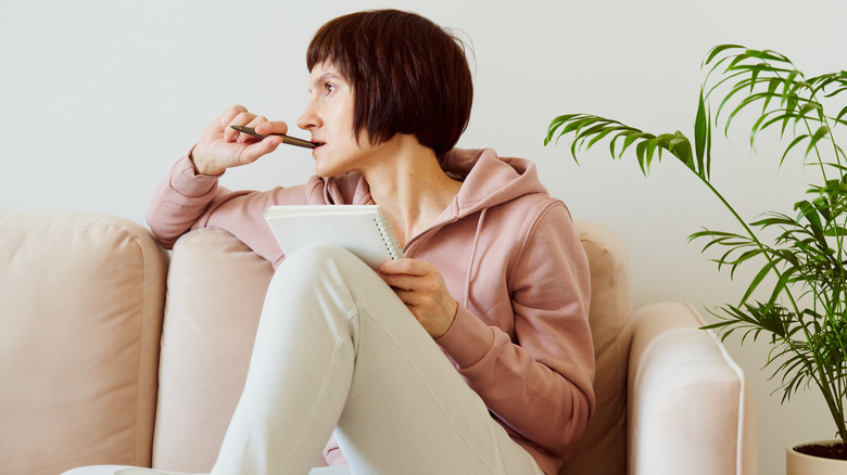 woman on sofa journaling