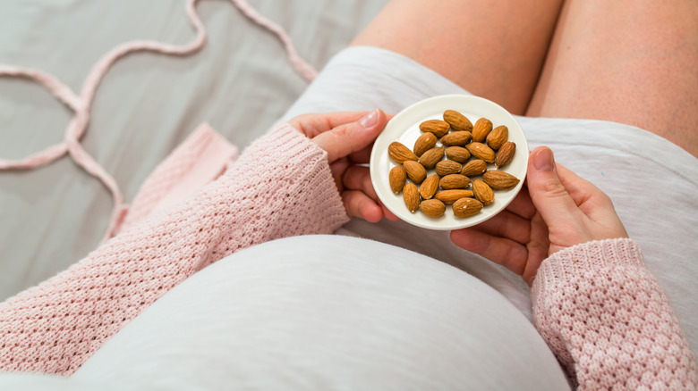 Pregnant woman eating almonds