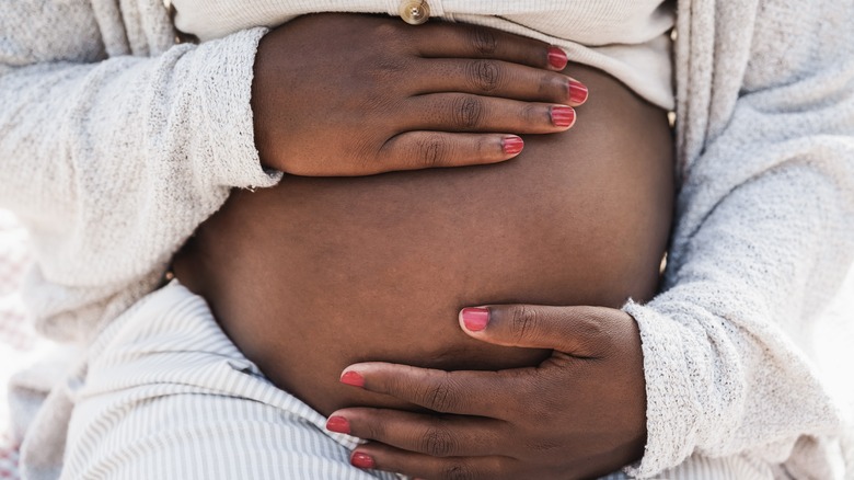 Pregnant woman holding stomach