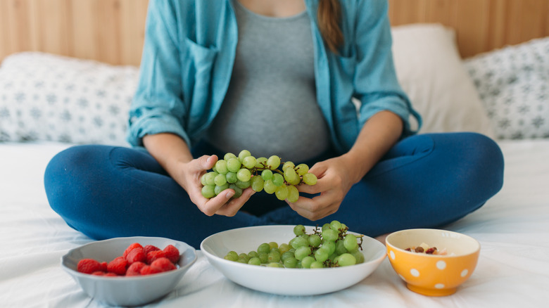 Pregnant woman eating grapes